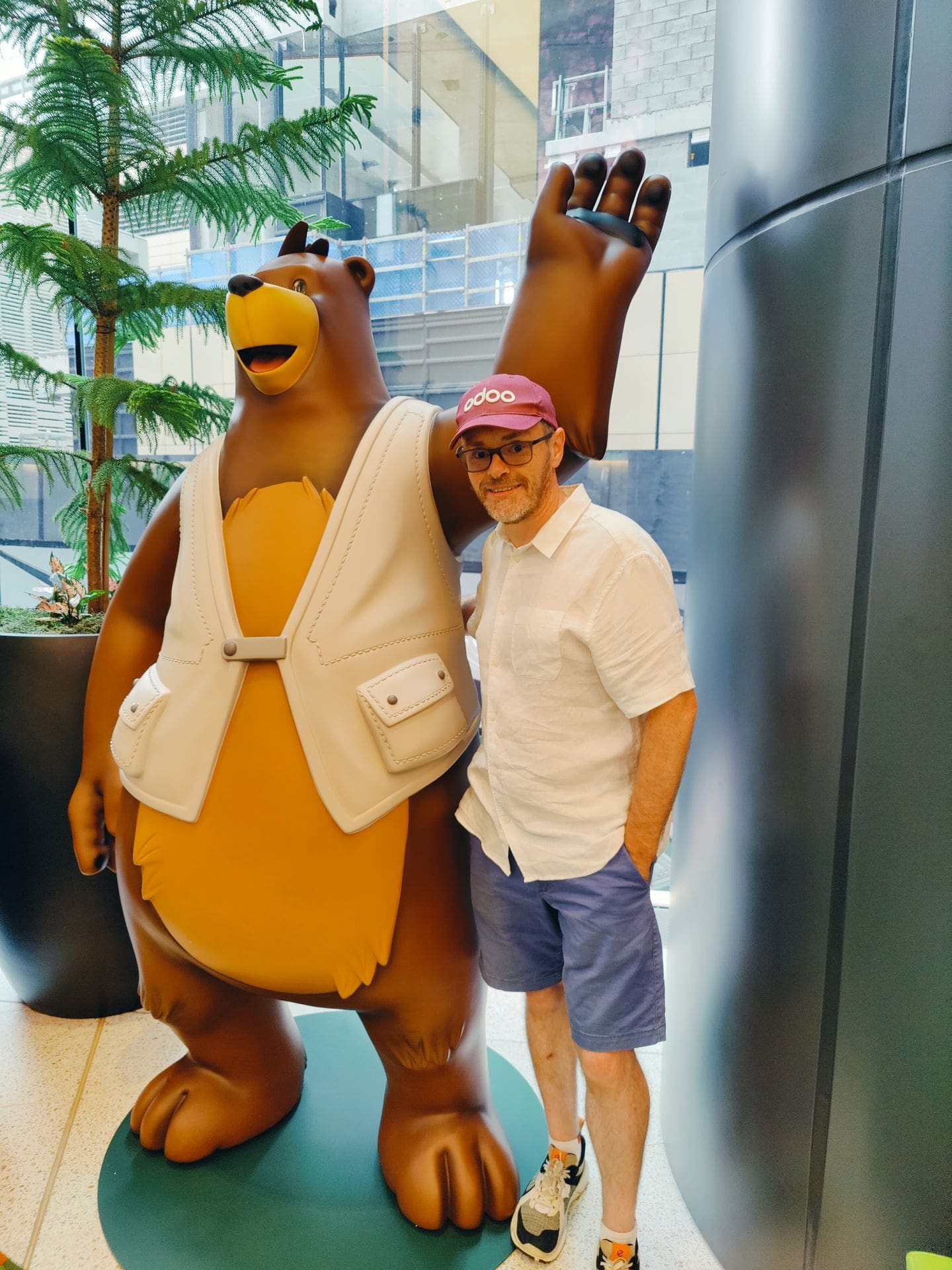 man standing next to Salesforce mascot Codey, the Bear